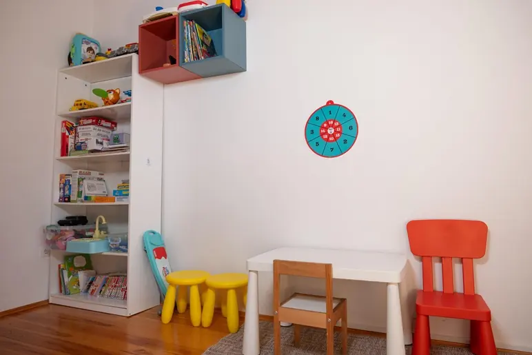 Renkli çocuk sandalyeleri, küçük masa ve oyuncak rafı