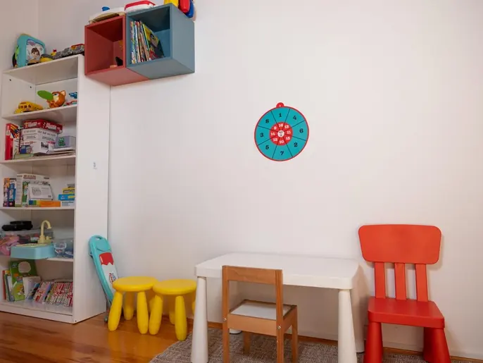 Renkli çocuk sandalyeleri, küçük masa ve oyuncak rafı