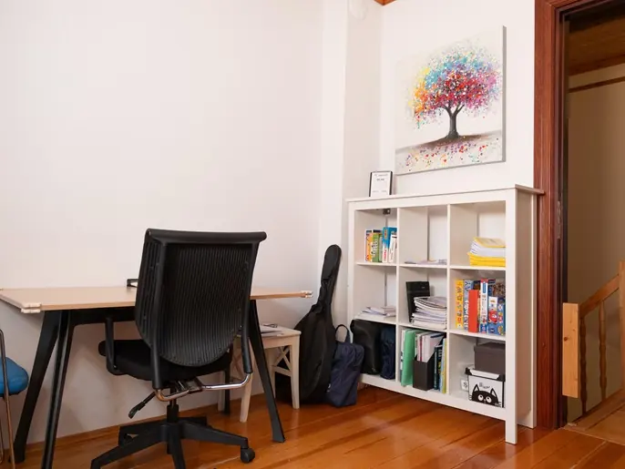 Masa, ergonomik sandalye ve kitaplıklı değerlendirme odası