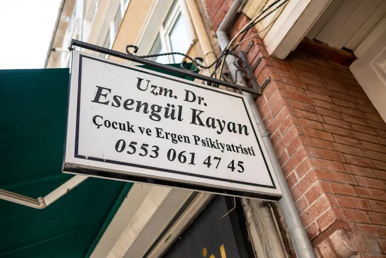 Merkezin girişindeki Uzm. Dr. Esengül Kayan, Çocuk ve Ergen Psikiyatristi tabelası