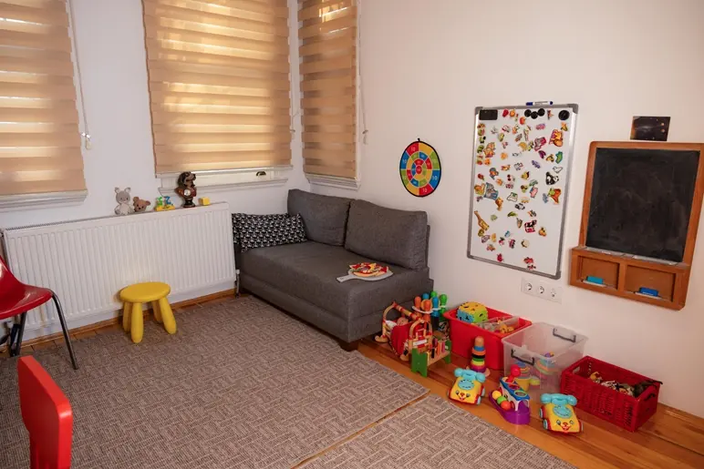 Kara tahta, mıknatıslı pano ve oyuncaklarla donatılmış çocuk terapi odası
